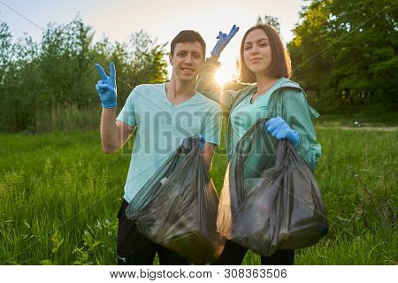 Friends Crouching With Bag Picking Up Trash Doing Plogging.plogging Concept. Boy And Girl Picking Up