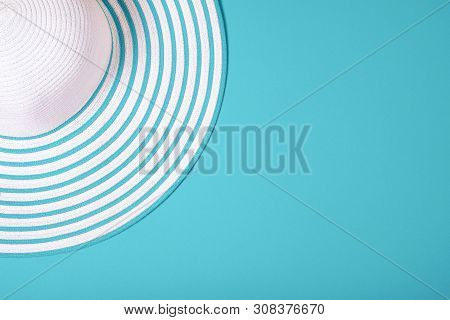 Summer And Vacation Concept. Top View Of Straw Striped Hat On Turquoise Trendy Color Background .fas