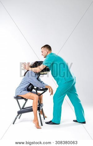 Theme Massage And Office. Male Therapist With Blue Suit Doing Back And Neck Massage For Young Woman 