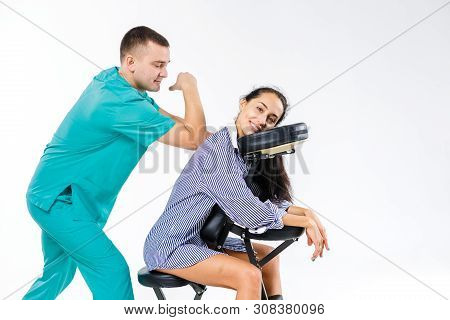 Theme Massage And Office. Male Therapist With Blue Suit Doing Back And Neck Massage For Young Woman 