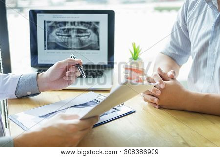 Dental Hygienist Demonstrating And Showing A Dummy Jaw To Chack-up Or Healing Teeth  Patient