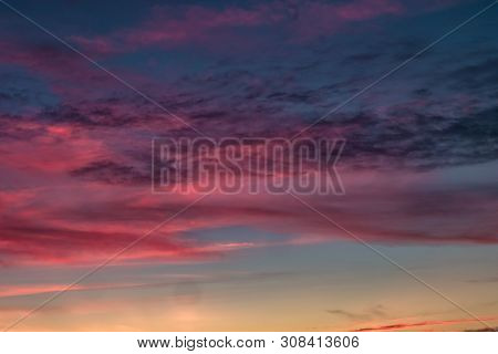 Blue Violet Red Sunset Sky Background With Evening Fluffy Curly Rolling Cirrostratus Clouds. Good Wi