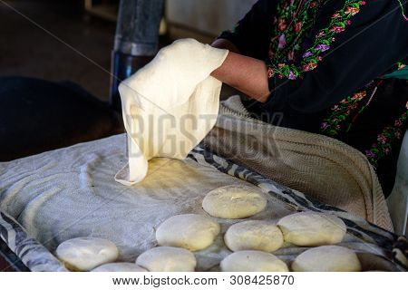 Close Up Arabian Old Woman Hand Cooking Flatbread Or Laffa Or Pita Bread For Ramadan Arabic Holiday.