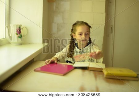 Pupil In School Uniform With Braids. Girl Schoolgirl At School With Book In School Uniform. Training