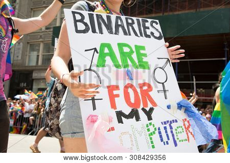 2018 JUNE 24 NEW YORK: NYC Pride March participant holds a sign that says Binaries Are For My Computer on the 5th Ave parade route.