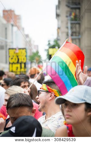 2018 JUNE 24 NEW YORK: NYC Pride March spectators wave rainbow flags and cheer the participants at 23rd St and 5th Ave.
