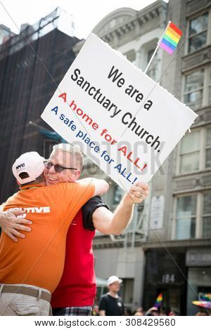 2018 JUNE 24 NEW YORK: NYC Pride March participant holds a sign that says We are A Santuary Church  on the 5th Ave parade route.