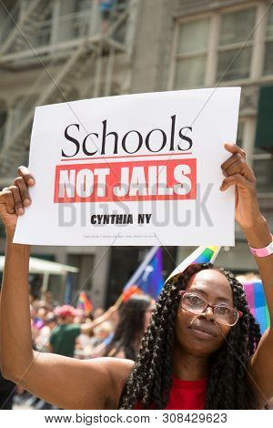 2018 JUNE 24 NEW YORK: NYC Pride March participant holds a sign that says Schools Not Jails on the 5th Ave parade route.