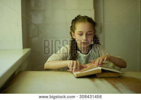 Pupil In School Uniform With Braids. Girl Schoolgirl At School With Book In School Uniform. Training