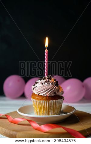 Happy Brithday Cupcake With A Candle On A Black Background With Pink Balloons