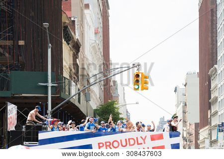 2018 JUNE 24 NEW YORK: NYC Pride March participants ride on the top deck of the SKYY Vodka Proudly American float on the 5th Ave parade route.