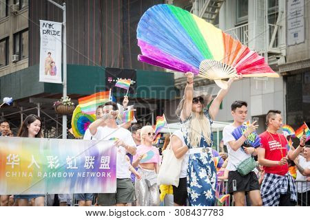 2018 JUNE 24 NEW YORK: NYC Pride March participants walk behind a China Rainbow Network banner on the 5th Ave parade route.