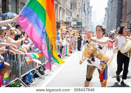 2018 JUNE 24 NEW YORK: NYC Pride March participants play drums for the cheering spectators on the 5th Ave parade route.