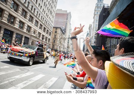 2018 JUNE 24 NEW YORK: NYC Pride March spectators wave rainbow flags and cheer the participants at 23rd St and 5th Ave.
