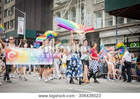 2018 JUNE 24 NEW YORK: NYC Pride March participants walk behind a China Rainbow Network banner on the 5th Ave parade route.