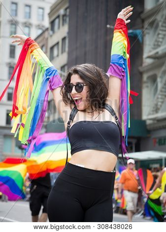 2018 JUNE 24 NEW YORK: NYC Pride March participant wearing a rainbow sleeve outfit walks along the 5th Ave parade route.