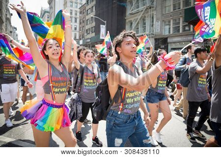2018 JUNE 24 NEW YORK: NYC Pride March participants wave rainbow flags as they walk along the parade route on 5th Ave.