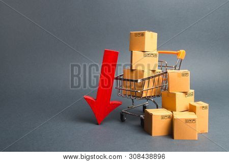 Shopping Cart Supermarket With Boxes And A Red Arrow Down. Falling Consumer Demand, Declining Export