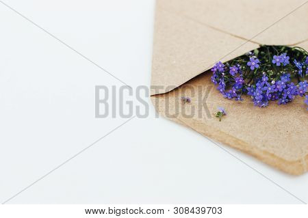 Little Cute Blue Forget-me-nots In A Kraft Paper Envelope, Selective Focus. Beautiful Bouquet Of Blu