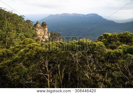 Two Of The Three Sisters Rock Formation Within The Forest In The Blue Mountains With Orange Last Sun