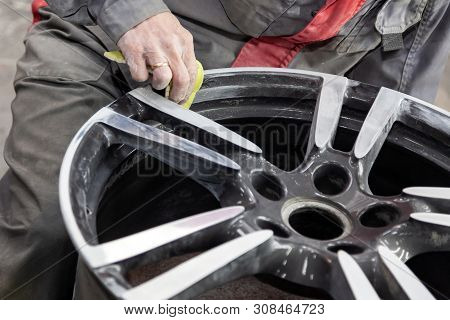 Master Body Repair Man Is Working On Preparing The Surface Of The Aluminum Wheel Of The Car For Subs