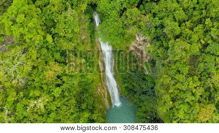 Aerial Top View Jungle Waterfall In A Tropical Forest Surrounded By Green Vegetation. Mantayupan Fal