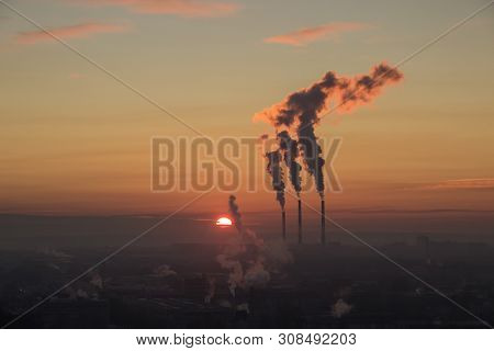 Aerial View Of Sunrise Over Industrial Zone In The City. Red Sun Comies Up.smoke Coming From The The
