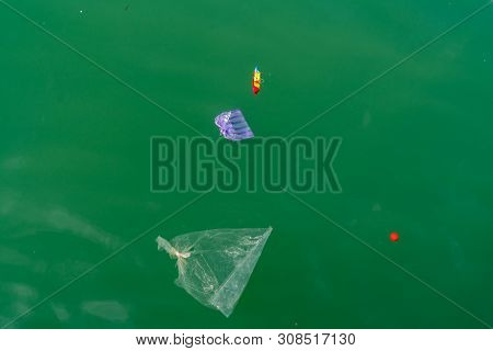 Waste Plastic Items Carelessly Disgarded Floating In Ocean Of Coast Of Borneo.