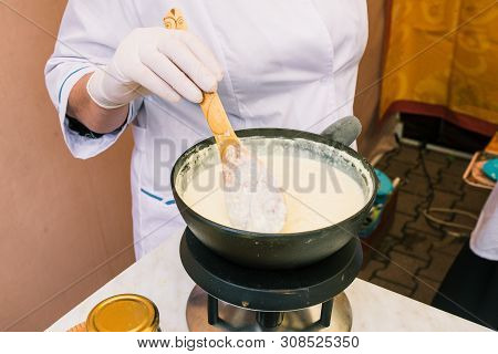 Making Cheese From Milk At Home. Female Hand Stir Cheese Sourdough With A Spoon In A Saucepan. Techn