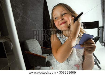 Interaction Of Children With Adult World. Cute Girl Trying To Do Bright Make Up For Being Older. Lit