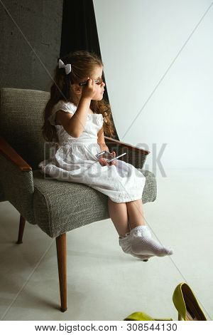 Interaction Of Children With Adult World. Cute Girl Trying To Do Bright Make Up For Being Older. Lit
