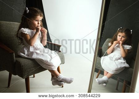 Interaction Of Children With Adult World. Cute Girl Trying To Do Bright Make Up For Being Older. Lit