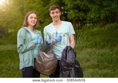 Friends Crouching With Bag Picking Up Trash Doing Plogging.plogging Concept. Boy And Girl Picking Up