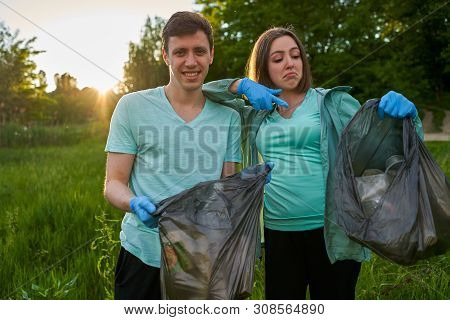 Friends Crouching With Bag Picking Up Trash Doing Plogging.plogging Concept. Boy And Girl Picking Up