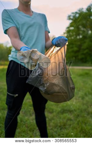 Blogging Concept. A Man Collects Trash From The Forest In The Trash Bag