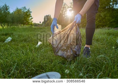 Blogging Concept. A Man Collects Trash From The Forest In The Trash Bag