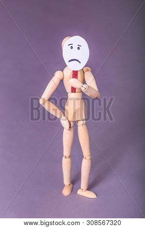 Sad Face Sign Held By Wooden Jointed Manikin Doll Standing In Studio Portrait