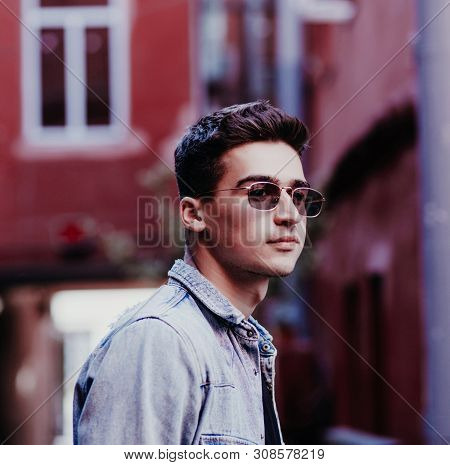 Close-up Portrait Of A Man In Glasses In An Urban Environmen