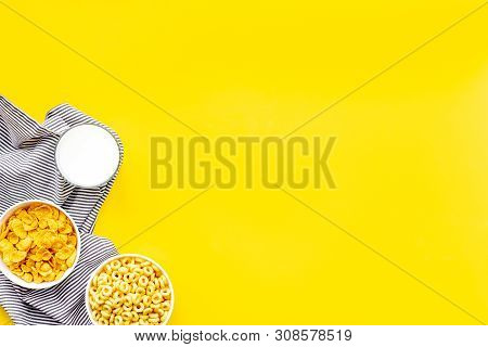 Cereals, Oatflakes And Cornflakes With Milk And Towel For Healthy Breakfast On Yellow Background Top