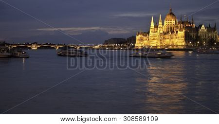 Evening View Of A Bridge Over Dunabe And An Illuminated Building Of Hungarian Parliament