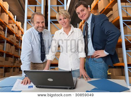 Team di business con un magazzino di stoccaggio allo sfondo