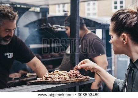 London, Uk - June 22,2019: Woman Sampling Grilled Meat At A Smokoloco Stall Inside Spitalfields Mark