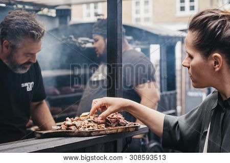 London, Uk - June 22,2019: Woman Sampling Grilled Meat At A Smokoloco Stall Inside Spitalfields Mark