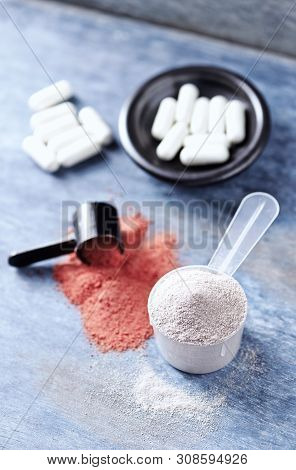 Scoop Of Whey Protein, Creatine Powder And Taurine Capsules. Sport Nutrition. Rustic Wooden Backgrou