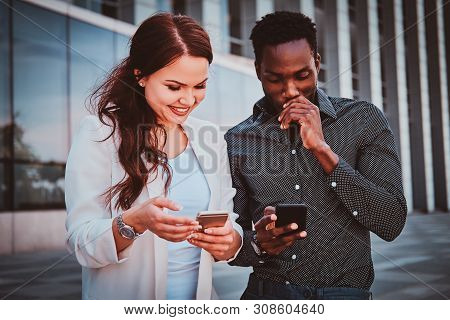 Two Joyful Busines Partners Are Meeting Up Near Glass Building At City Centre.