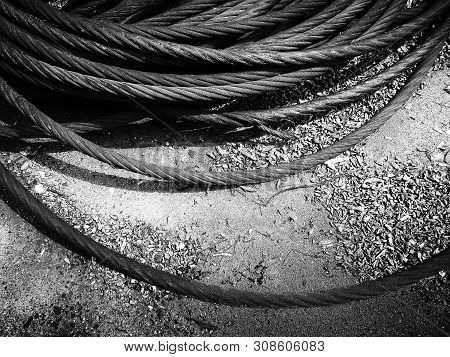 Old Rusty Strong Cable Rolled Into The Bay. The Rings Of Iros Are Located On The Ground, The Yard Of