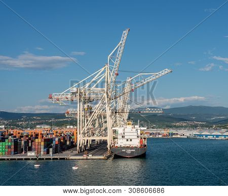 Koper, Slovenia - 24 May 2019: Cranes Load Containers Onto Ship In The Container Port Of Koper In Sl
