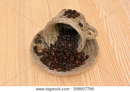 Coffee Beans In A Decorative Cup And Saucer On The Wooden Table.
