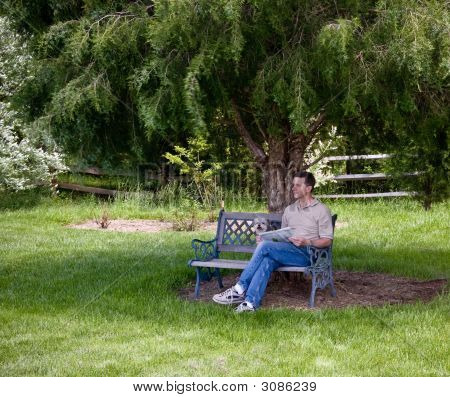 Muž a štěně relaxovat pod stromem