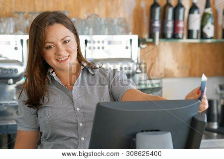 Bartender Registrating New Order By Cash Register. A Restaurant Waitress Registrating New Order By C